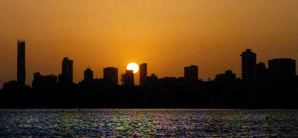 The sun sets over a stretch of the skyline in Mumbai, India.