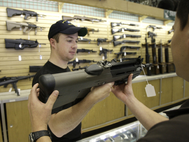 Case Vermillion hands a gun to a customer at the Cheaper Than Dirt gun shop in Fort Worth, Texas, Thursday, Nov. 6, 2008.