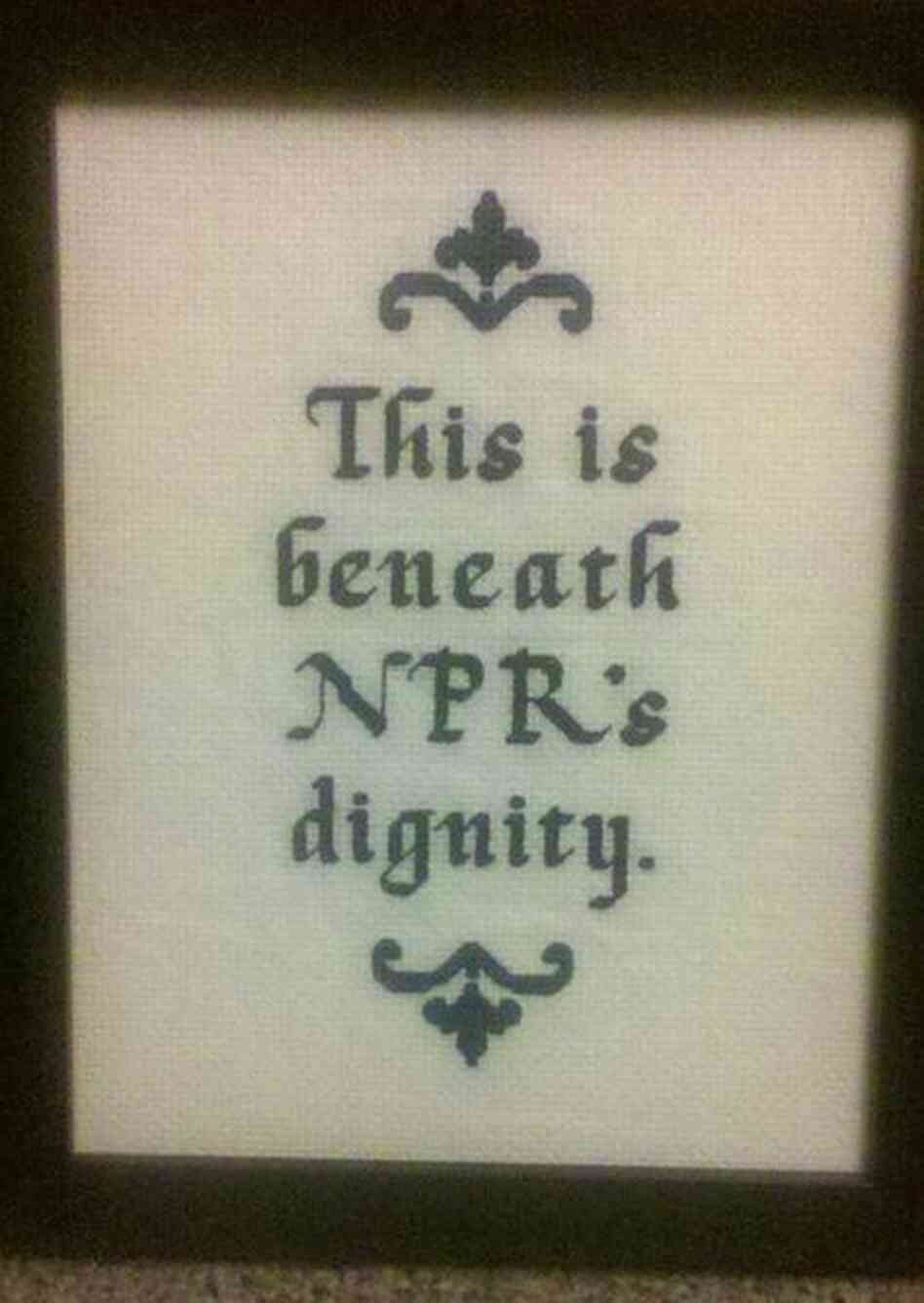 A wall hanging reading "This is beneath NPR's dignity." A wall hanging reading "This is beneath NPR's dignity."