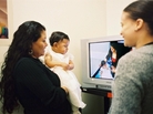 A mother watches a video taken of herself playing with her daughter for Bellevue Hospital's Video Interaction Project. Former hospital employee Brenda Woodford reviews the footage, offering positive feedback and areas for improvement. A mother watches a video taken of herself playing with her daughter for Bellevue Hospital's Video Interaction Project. Former hospital employee Brenda Woodford reviews the footage, offering positive feedback and areas for improvement.