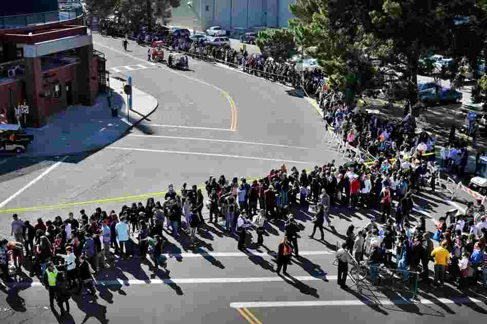 People wait in line for the memorial service honoring Saturday's shooting victims on the University of Arizona campus in Tuscon. 