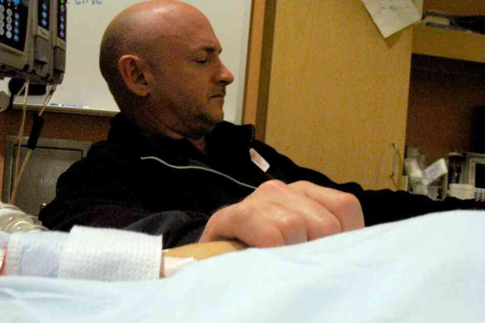 Giffords' husband, Mark Kelly, holds his wife's hand in the congresswoman's hospital room at University Medical Center in Tucson. Giffords remained in critical condition Wednesday. 