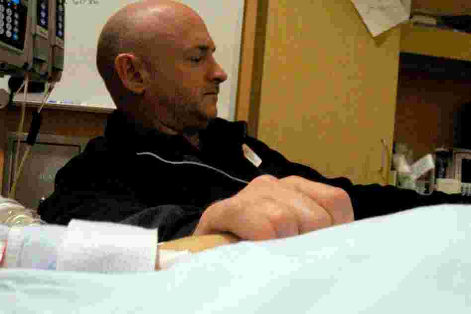 Giffords' husband, Mark Kelly, holds his wife's hand in the congresswoman's hospital room at University Medical Center in Tucson. Giffords remained in critical condition Wednesday. 