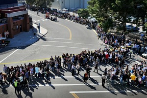People wait in line for the memorial service honoring Saturday's shooting victims on the University of Arizona campus in Tuscon.