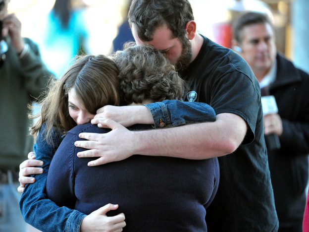 A Tucson family embraces outside Rep. Gabrielle Giffords' office after Saturday's shooting.
