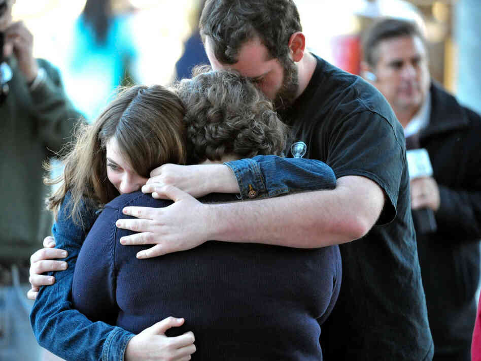 A Tucson family embraces outside Rep. Gabrielle Giffords' office after Saturday's shooting.