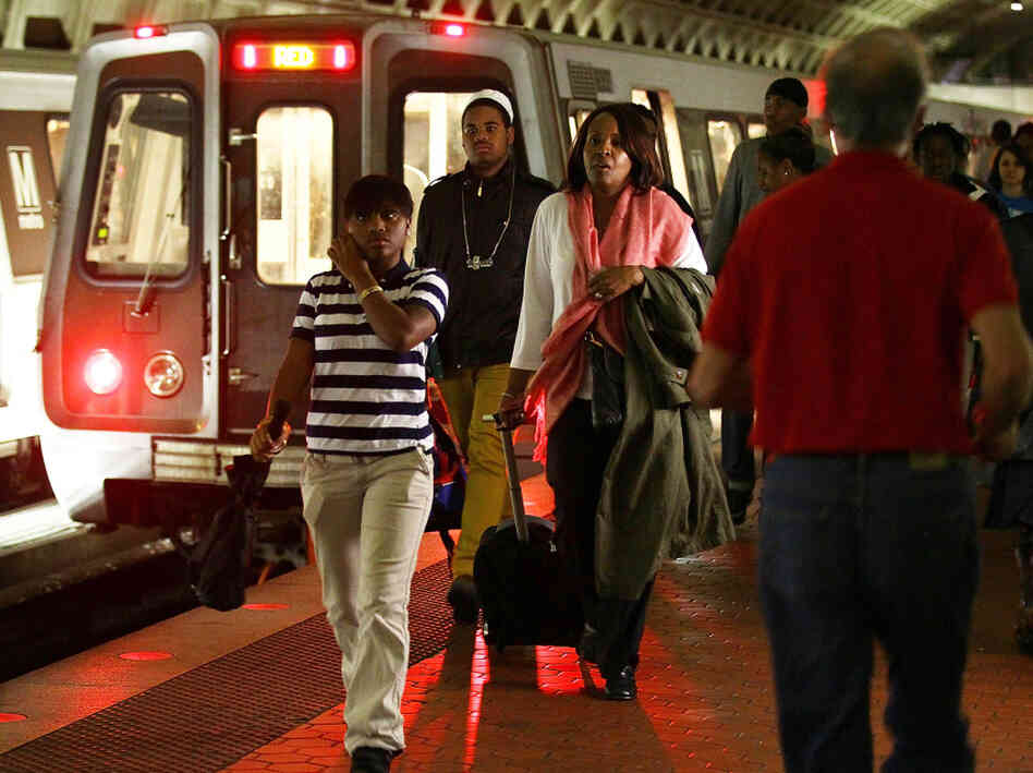 Passengers walk along the platform at a commuter train station in Washington, D.C.