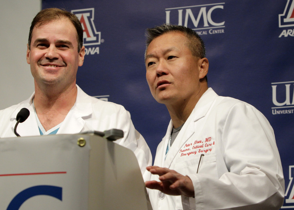 Dr. G. Michael Lemole, Jr., left, looks on as Dr. Peter Rhee talks about the condition of U.S. Rep. Gabrielle Giffords (D-AZ), at University Medical Center during a news conference in Tucson, Ariz., Monday, Jan. 10, 2011.