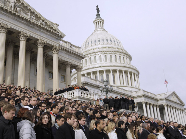 Members of Congress and staff members observe a moment of silence Monday for Rep. Gabrielle Giffords and the other Tucson shooting victims on the East Steps of the Capitol.