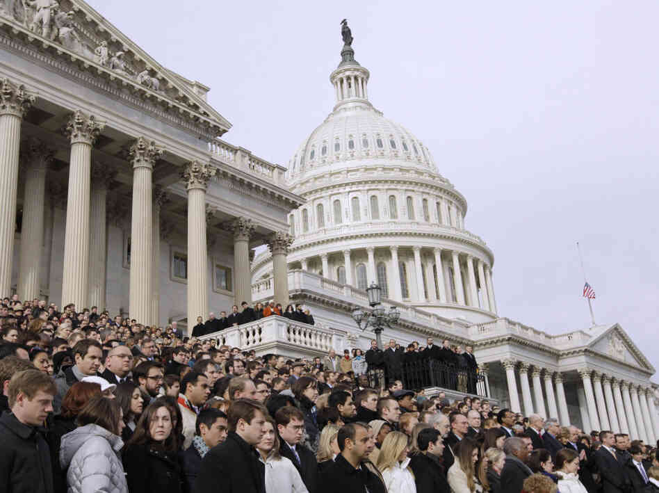 Members of Congress and staff members observe a moment of silence Monday for Rep. Gabrielle Giffords and the other Tucson shooting victims on the East Steps of the Capitol.