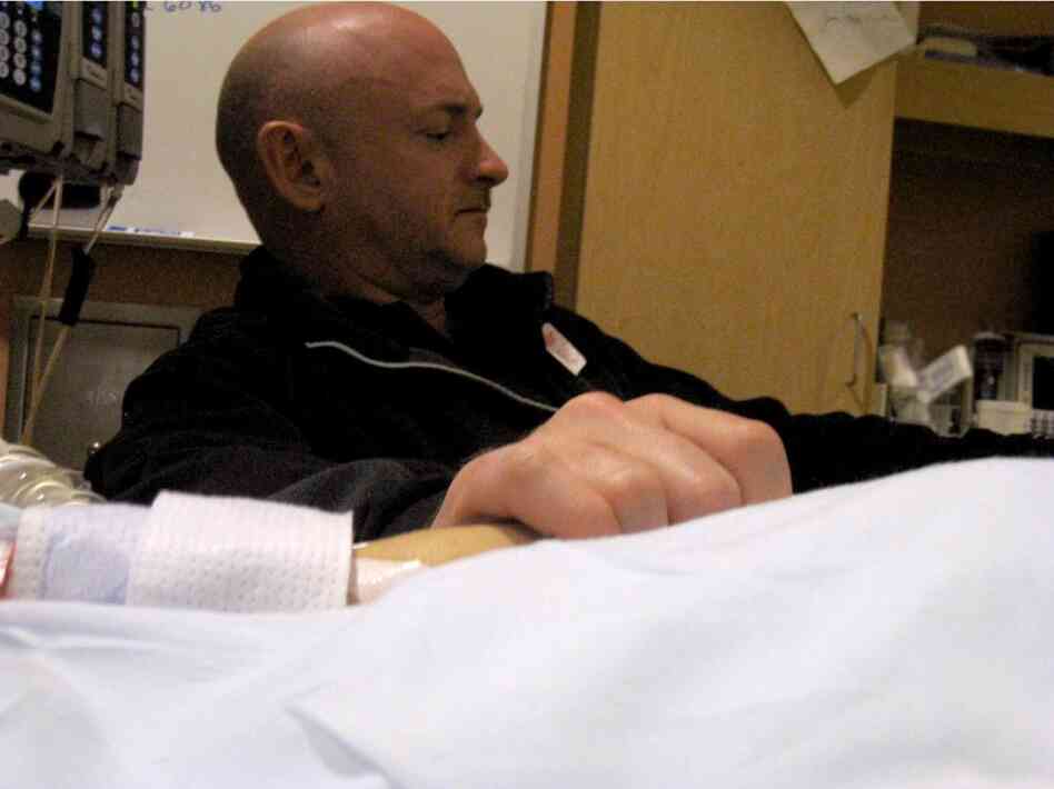 Giffords' husband, Mark Kelly, holds his wife's hand in the congresswoman's hospital room at University Medical Center in Tucson. Giffords remained in critical condition Wednesday. 