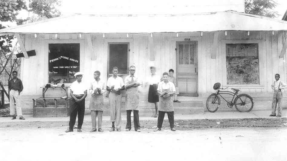 Frank Morris (in the apron and visor) is seen standing in front of his shoe shop in the 1950s. He was killed when his shoe shop burned down in Ferriday, La., in 1964.