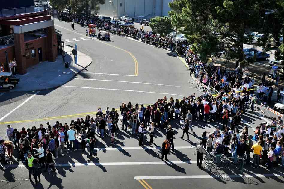 People wait in line for the memorial service at the University of Arizona campus in Tucson. 