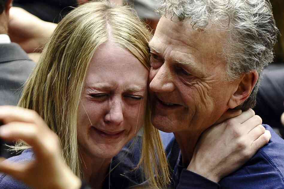 A woman is comforted at the University of Arizona's McKale Center. 