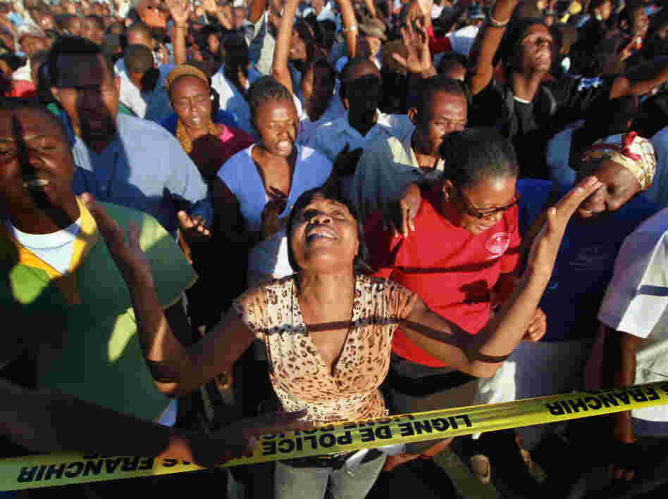 People attend a prayer service near the Presidential Palace in memory of those killed a year ago in the massive earthquake in Haiti. With much of the aid money unspent, the country struggles to repair the damage. People attend a prayer service near the Presidential Palace in memory of those killed a year ago in the massive earthquake in Haiti. With much of the aid money unspent, the country struggles to repair the damage.