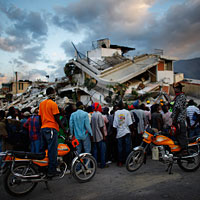 Haitians watch the L.A. County Search and Rescue working at a collapsed building in downtown Port-au-Prince, Jan. 16, 2010.