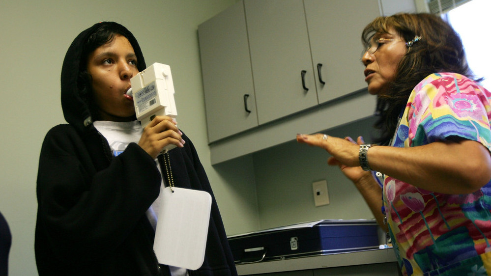 Nurse Maria Aguilar encourages teenager Jesus Ayala during a test of his lung capacity at a Los Angeles clinic in 2007.