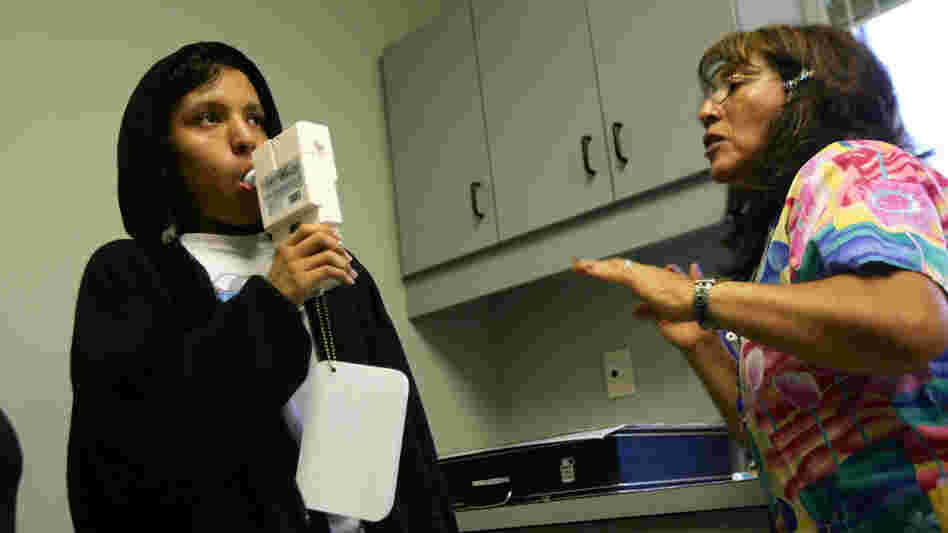 Nurse Maria Aguilar encourages teenager Jesus Ayala during a test of his lung capacity at a Los Angeles clinic in 2007.