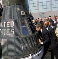 President Kennedy gets a look inside the Mercury capsule that was piloted by John Glenn (at Kennedy's right) on Feb. 23, 1962.