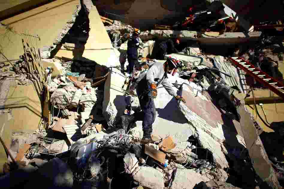 A rescue team from south Florida tries to reach survivors in a collapsed supermarket near downtown Port-au-Prince, Jan. 16, 2010.