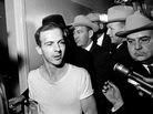 Surrounded by detectives, Lee Harvey Oswald talks to the press as he is led down a corridor of the Dallas police station after the assassination of U.S. President John F. Kennedy. Surrounded by detectives, Lee Harvey Oswald talks to the press as he is led down a corridor of the Dallas police station after the assassination of U.S. President John F. Kennedy.
