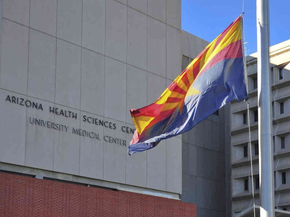 The flag of the state of Arizona flies at half-staff outside University Medical Center in Tucson, Ariz., on Jan. 8.