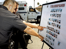 Los Angeles police officers point to known local gang suspects after a federal gang raid operation in Los Angeles on Aug. 25, 2010. Los Angeles police officers point to known local gang suspects after a federal gang raid operation in Los Angeles on Aug. 25, 2010.