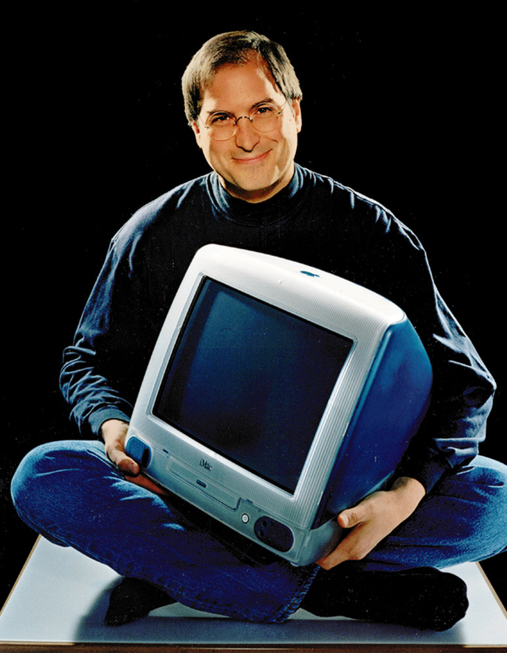 A 1998 photo of Apple CEO Steve Jobs, holding an iMac Computer.