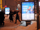 People walk past posters reading in Estonian "Euro is our money."