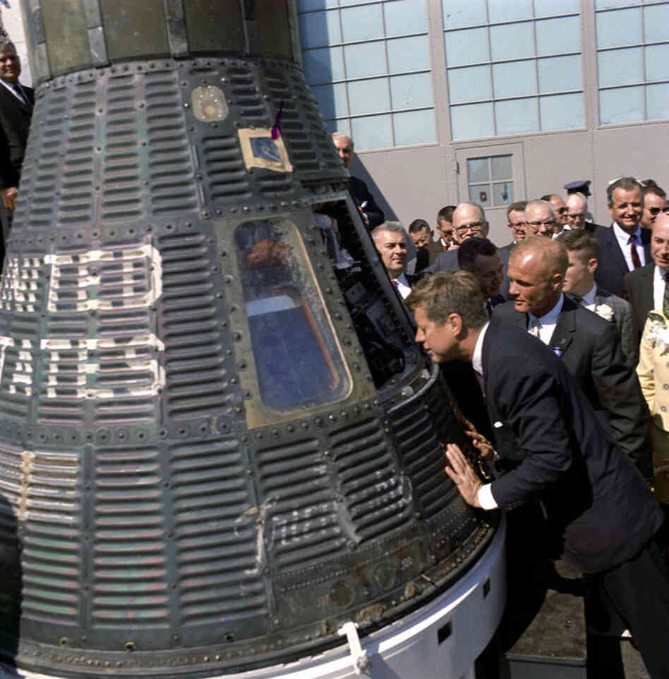 President Kennedy gets a look inside the Mercury capsule that was piloted by John Glenn (at Kennedy's right) on Feb. 23, 1962.  