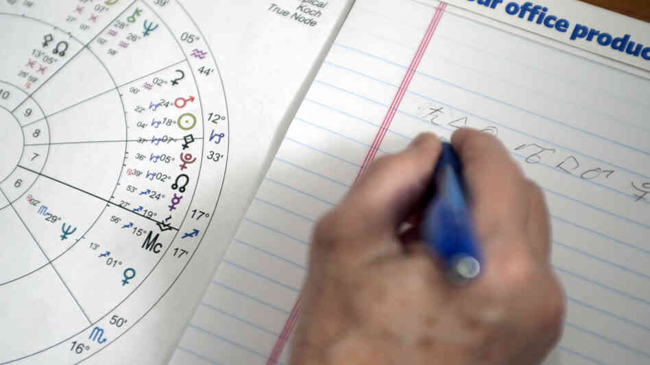 An astrologist works on an astrological chart.