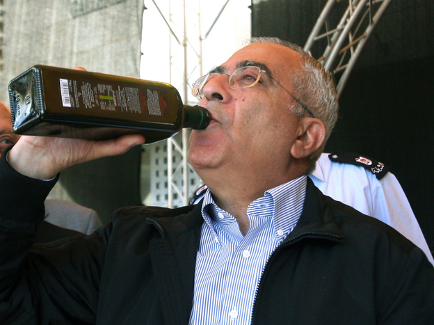 Palestinian prime minister Salam Fayyad tastes freshly pressed and bottled olive oil in Bethlehem.