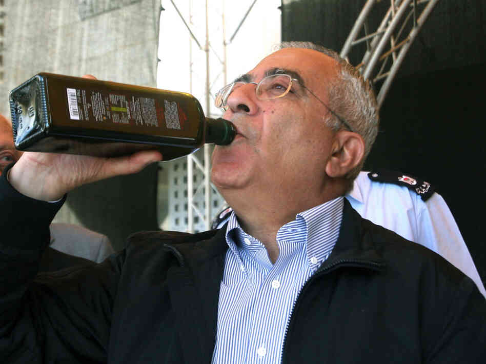 Palestinian prime minister Salam Fayyad tastes freshly pressed and bottled olive oil in Bethlehem.