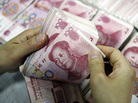 A Chinese bank worker counting stacks of 100 yuan notes. A Chinese bank worker counting stacks of 100 yuan notes.