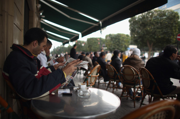 A Tunisian man reads a newspaper at a cafe in Tunis on Thursday. The press was censored during Zine El Abidine Ben Ali's 23-year rule. That changed overnight last Friday when he and his wife fled the country.