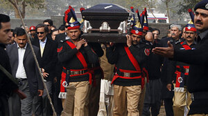 Pakistani police guards carry the coffin of the assassinated governor of Punjab, Salman Taseer, during the funeral procession in Lahore on Jan. 5.