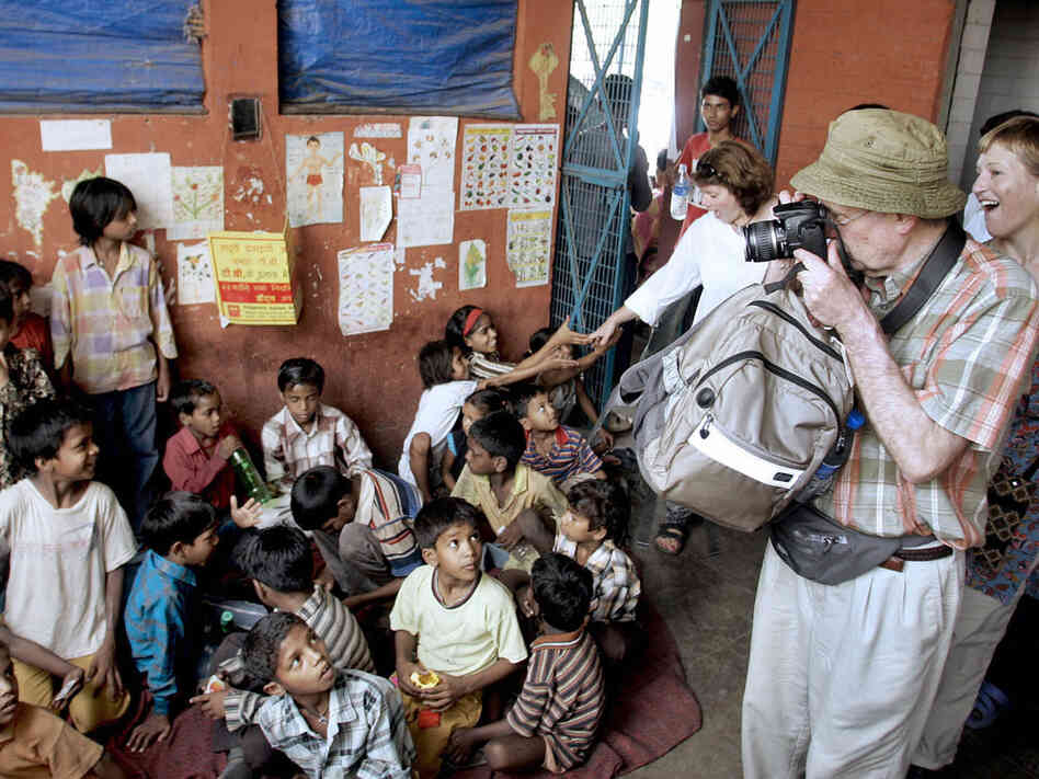 Tourists take photographs of street children at the railway station in New Delhi in May 2006. Salaam Baalak Trust runs two-hour guided tours that take visitors through the chaos of the area. Tourists take photographs of street children at the railway station in New Delhi in May 2006. Salaam Baalak Trust runs two-hour guided tours that take visitors through the chaos of the area.