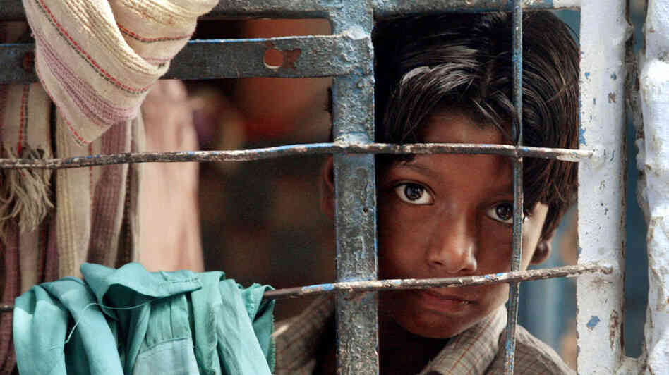 A street child looks out from his classroom during studies conducted by the Salaam Baalak Trust at the New Delhi railway station in September 2004. Salaam Baalak Trust is an Indian charity for homeless children. A street child looks out from his classroom during studies conducted by the Salaam Baalak Trust at the New Delhi railway station in September 2004. Salaam Baalak Trust is an Indian charity for homeless children.