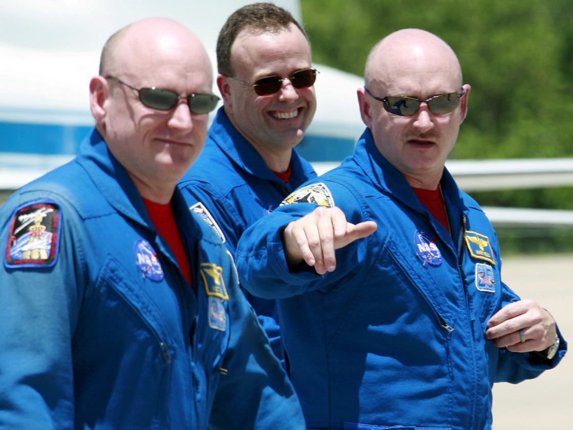 May 28, 2008, file photo: Space shuttle Discovery commander Mark Kelly, right, gestures as he walks with his twin brother astronaut Scott Kelly, left, and mission specialist Ron Garan, after arrival at Kennedy Space Center in Cape Canaveral, Fla.