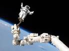 Mission Specialist Stephen K. Robinson works from a boom arm connected to the International Space Station. Mission Specialist Stephen K. Robinson works from a boom arm connected to the International Space Station.