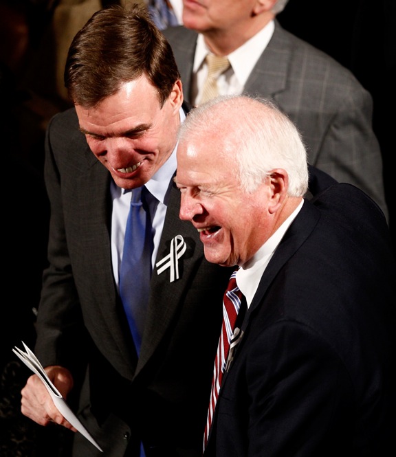 Sen. Mark Warner (D-VA), left, and Sen. Saxby Chambliss (R-GA), share a laugh as they prepare to sit together. 