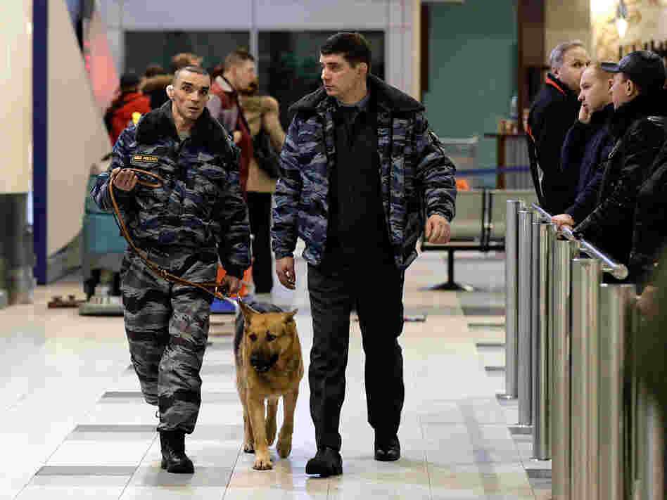 Police officers walk with a sniffing dog through Domodedovo Airport in Moscow on Jan. 24, after a blast that killed dozens of people.