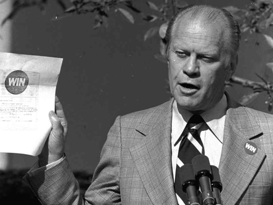 President Ford holds up a WIN, or "Whip Inflation Now," enlistment form, which asks citizens to sign up as inflation fighters during his news conference in the White House Rose Garden on Oct. 9, 1974. The slogan turned out to be a dud.
