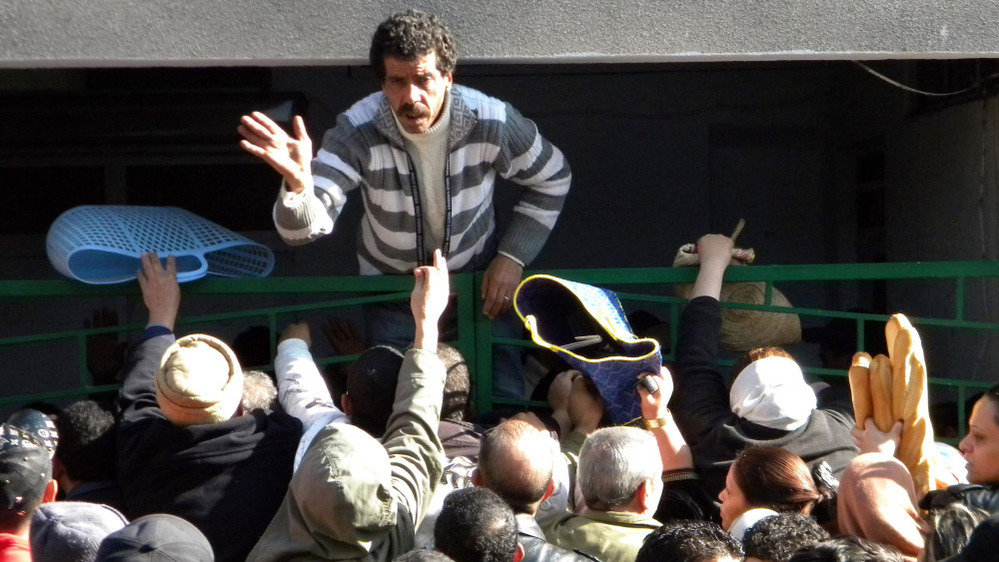 Tunisians wait outside a bakery to buy bread in Tunis on Jan. 16, 2011.