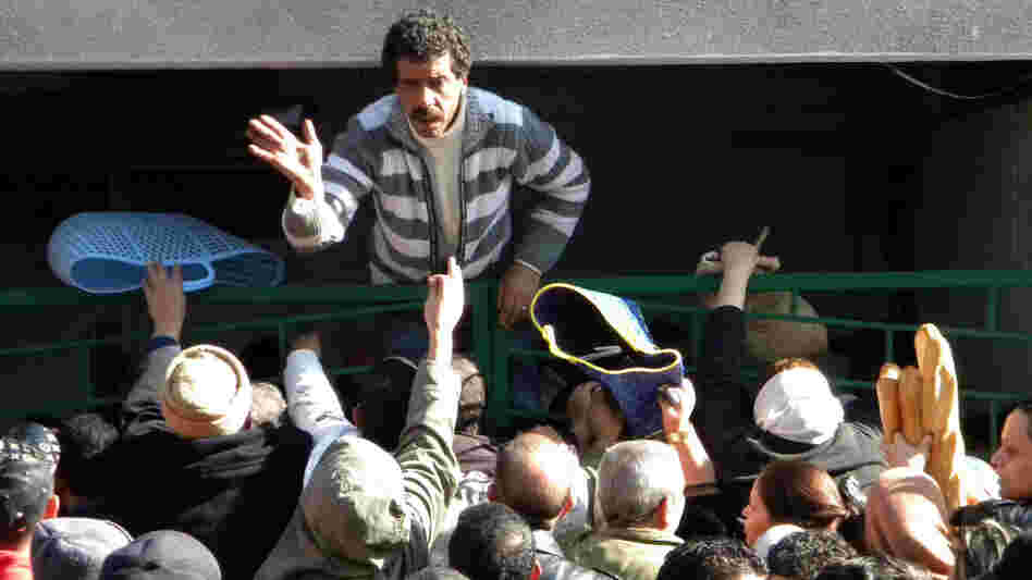 Tunisians wait outside a bakery to buy bread in Tunis on Jan. 16, 2011.