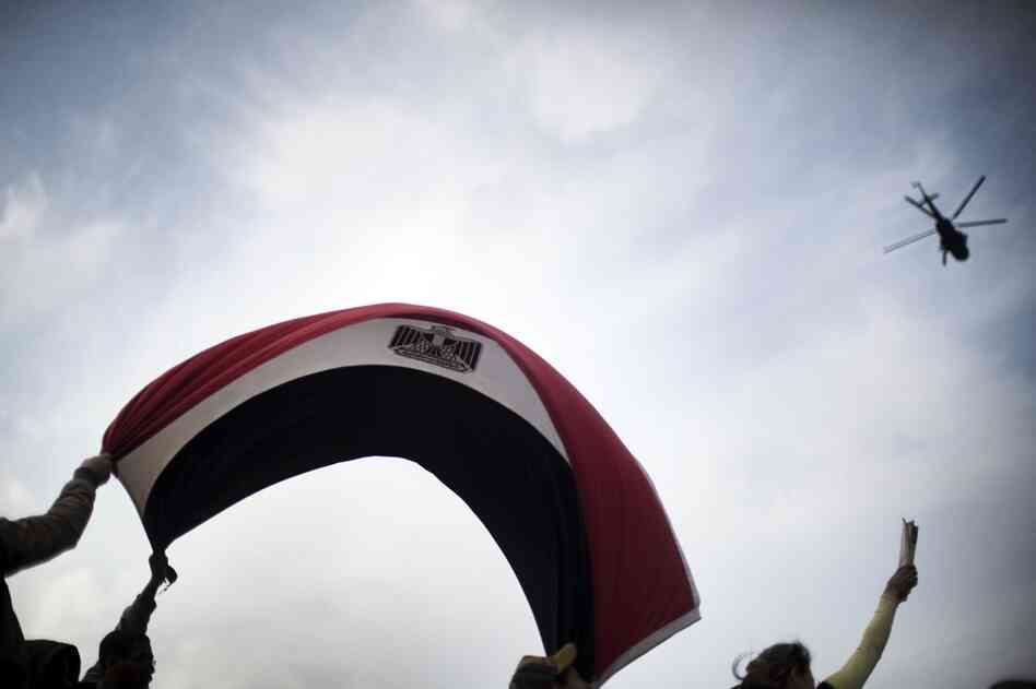 A military helicopter flies low over Tahrir Square on Sunday. Fighter jets swooped low over Cairo Sunday in what appeared to be an attempt by the military to show its control of a city in upheaval. 