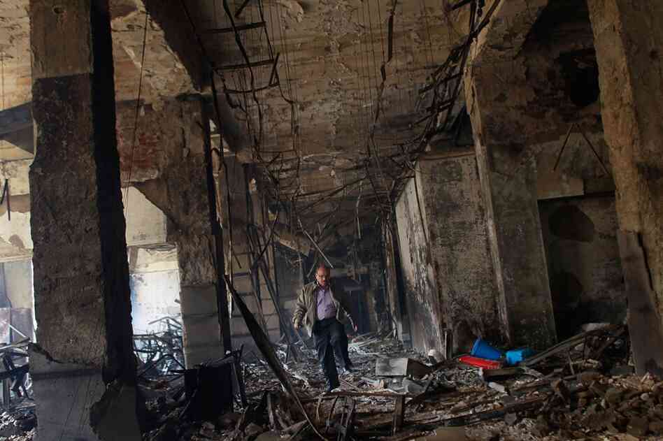 A man walks through the charred remains of a burned government building in Cairo on Sunday. 