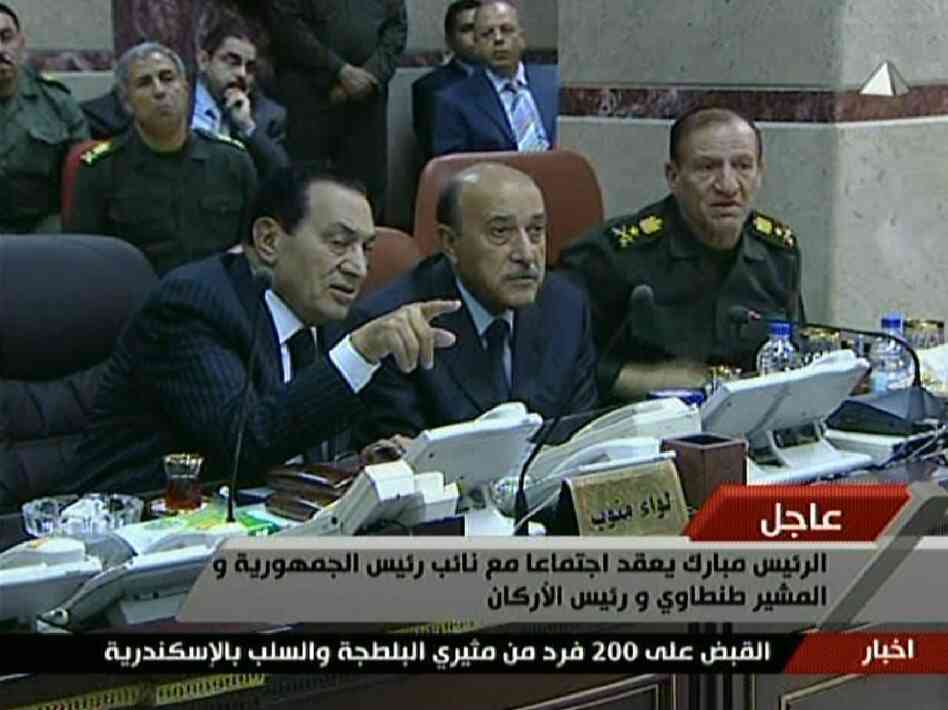 An image grab taken from Egyptian state television shows Egyptian President Hosni Mubarak (left) speaking with his new Vice President Omar Suleiman (center) and Chief of Staff Sami Anan during a visit to the military operations center in Cairo on Sunday.