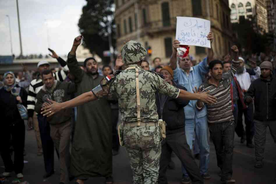 An Egyptian army soldier tries to stop anti-government protesters as they walk towards Tahrir Square on Sunday. 