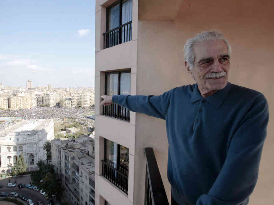 Egyptian film star  Omar Sharif points to Tahrir, or Liberation, Square, in Cairo, Egypt, Monday Jan. 31, 2011. A coalition of opposition groups called for a million people to take to Cairo's streets Tuesday to demand the removal of President Hosni Mubarak. (AP Photo/Lefteris Pitarakis)